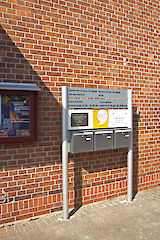 Aufsteller mit Säule 90 mm, Textpaneel 150/200 mm und bauseitig aufgesetzten Briefkästen. Profiloberfläche: eloxiert silber / pulverbeschichtet nach RAL 9010